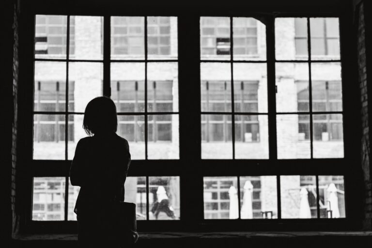 Silhouetted person behind a window, representing an inner battle for motivation