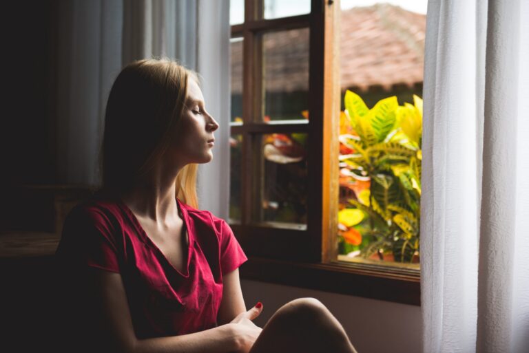 Woman sitting quietly in meditation to cultivate peace, clarity, and healing