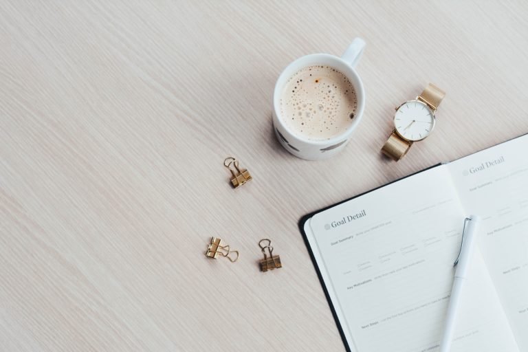 Coffee and goals journal on desk