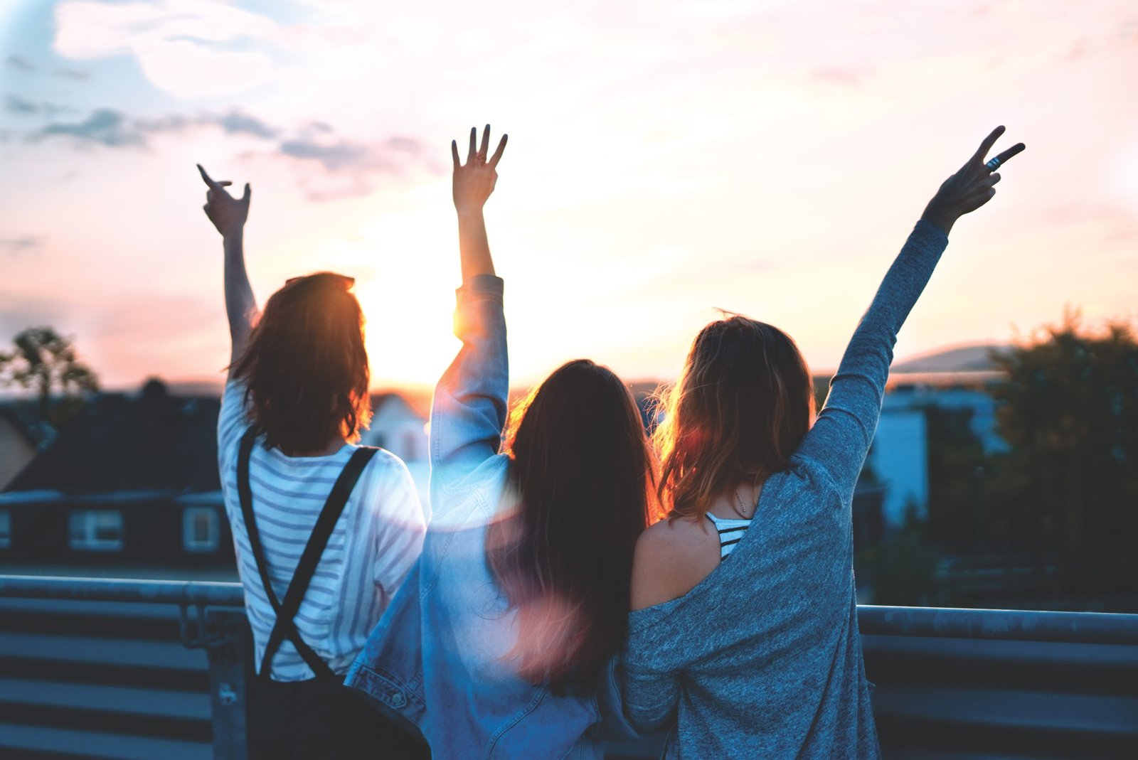 3 women with their hands in the air