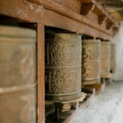 old prayer wheels with ornament in buddhist temple