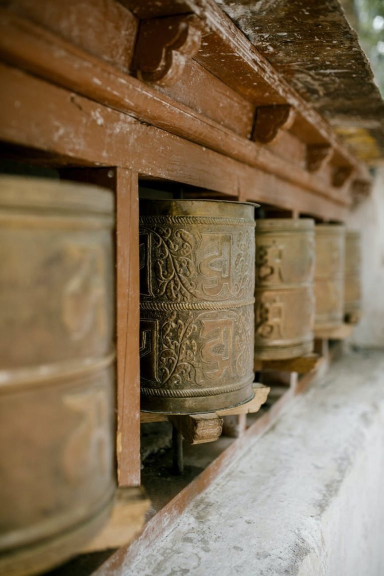 old prayer wheels with ornament in buddhist temple