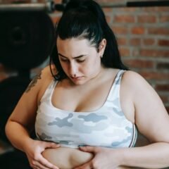 unhappy young overweight woman touching stomach before abs workout