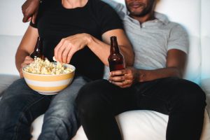 Couple relaxing together on a couch during a Thanksgiving movie night