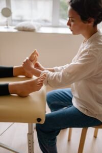Practitioner applying pressure to a client’s foot during a reflexology session