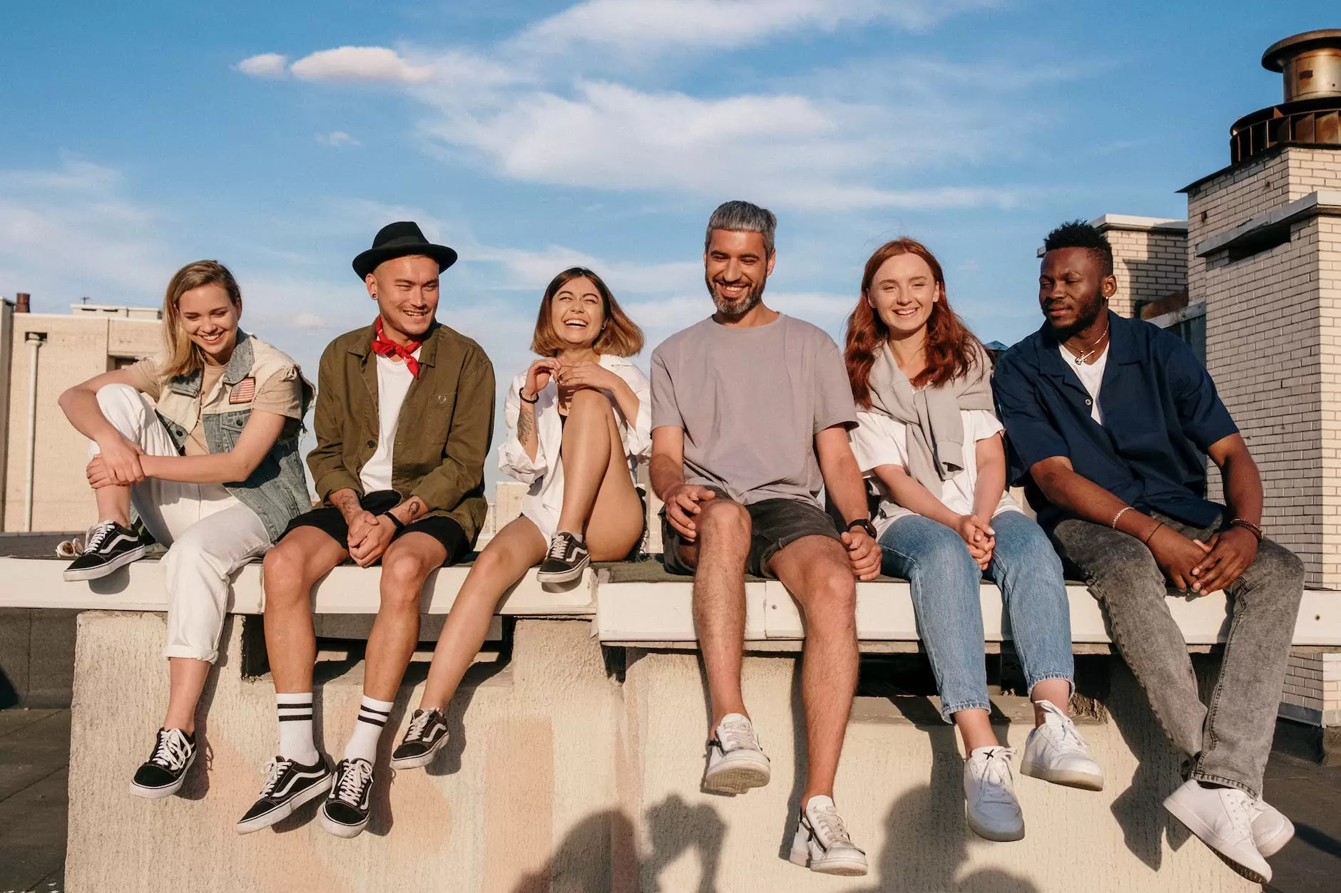Group of young adults sitting together on a concrete bench