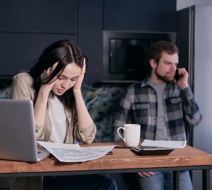 Woman feeling overwhelmed while reviewing documents and bills at a desk, photographed by Mikhail Nilov on Pexels